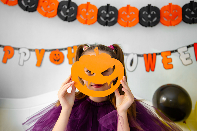 Girl with pumpkin cutout mask during Halloween